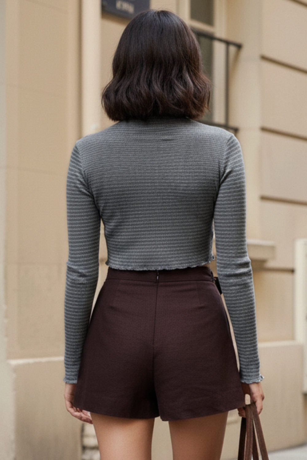 Falda short corto de cintura alta, corte en a, sobrefalda con cruce frontal, lazo lateral amarrable y cierre posterior con cremallera oculta.