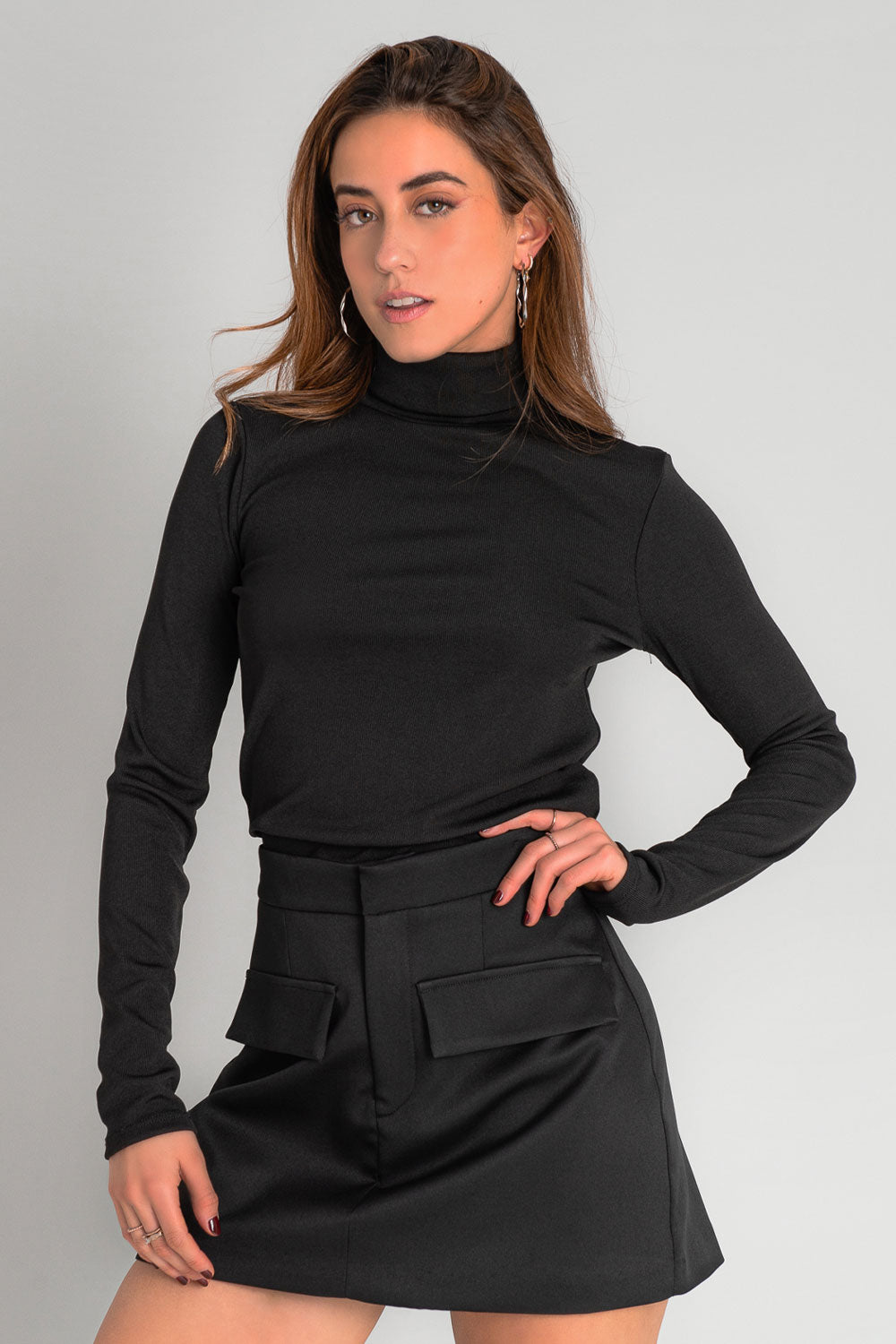 Falda short corto de cintura alta con pretina, corte en a, bolsillos delanteros decorativos con cartera y cierre frontal con broche y cremallera oculta.