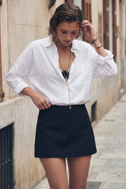 Falda short corto de fit ajustado, cintura media y cierre lateral con cremallera oculta.