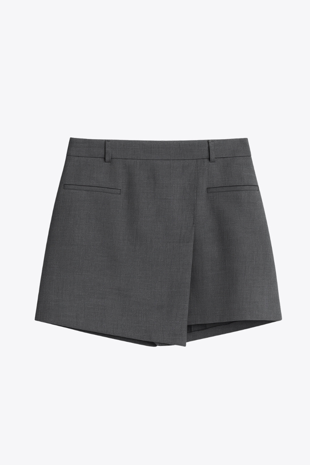 Falda short corto de cintura alta con pretina y trabillas, corte en a, cruce frontal en diagonal y vivos decorativos frontales. Cierre lateral con cremallera oculta.