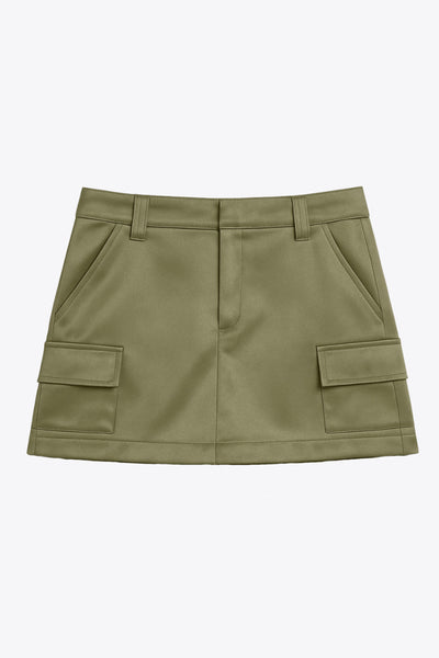 Falda short corto satinado de cintura alta con pretina y trabillas, corte en a, bolsillos delanteros y laterales cargo con cartera. Cierre frontal con broche y cremallera ocultos.
