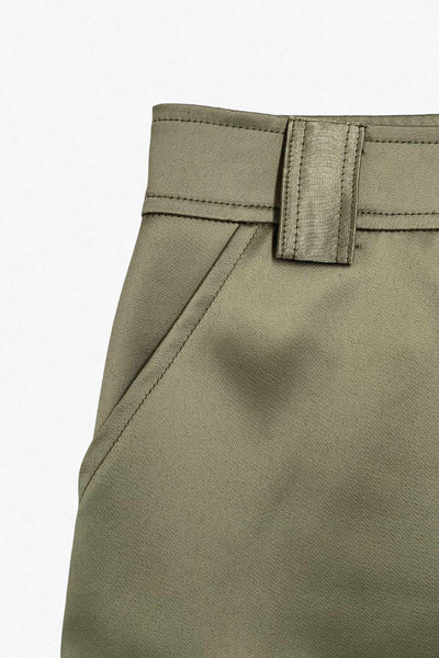 Falda short corto satinado de cintura alta con pretina y trabillas, corte en a, bolsillos delanteros y laterales cargo con cartera. Cierre frontal con broche y cremallera ocultos.