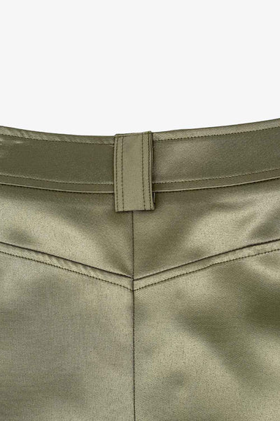 Falda short corto satinado de cintura alta con pretina y trabillas, corte en a, bolsillos delanteros y laterales cargo con cartera. Cierre frontal con broche y cremallera ocultos.