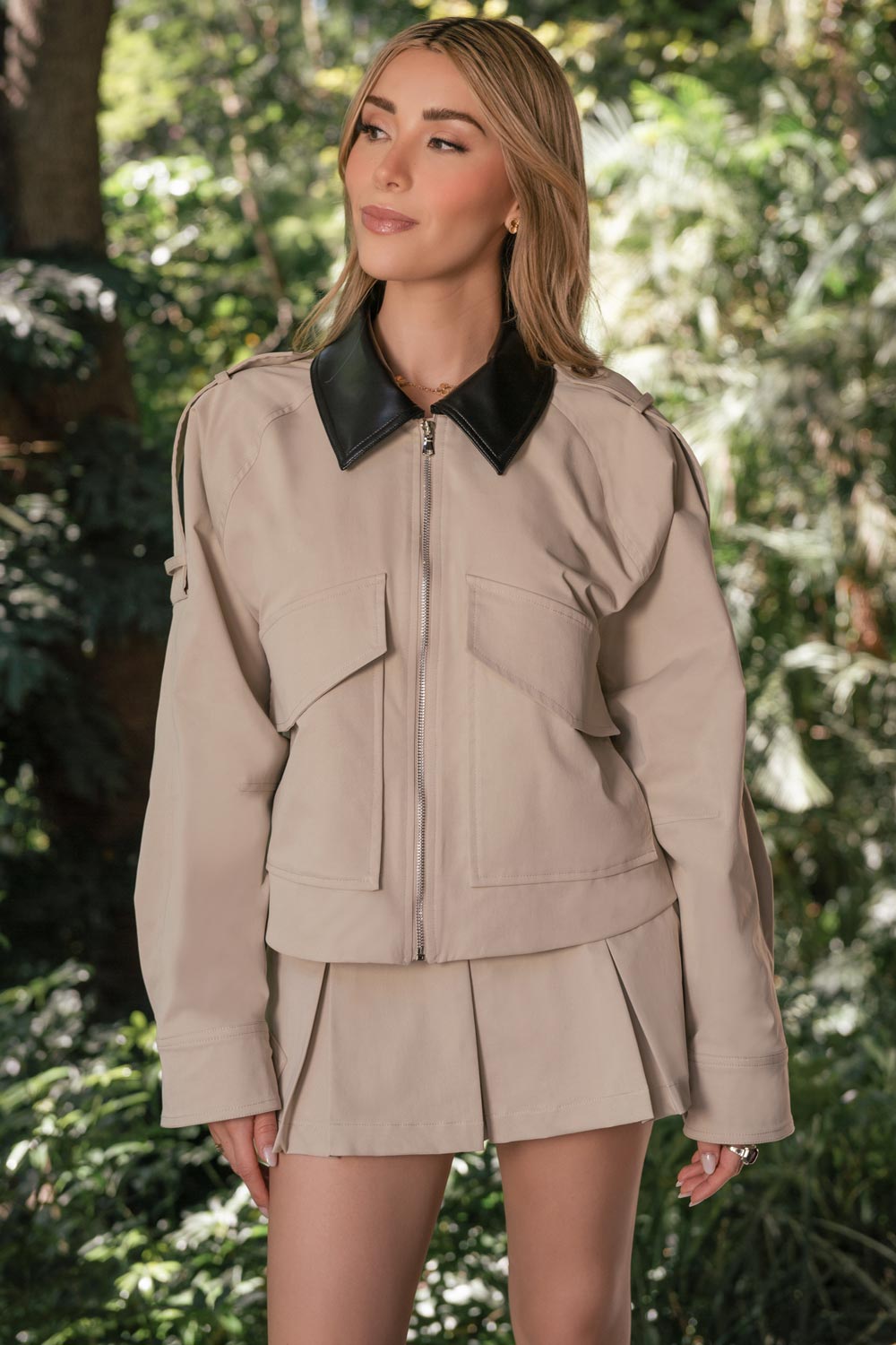 Falda short corto de cintura alta con pretina y trabillas, corte en a, tableado en bajo, cierre frontal con botón y cremallera oculta.