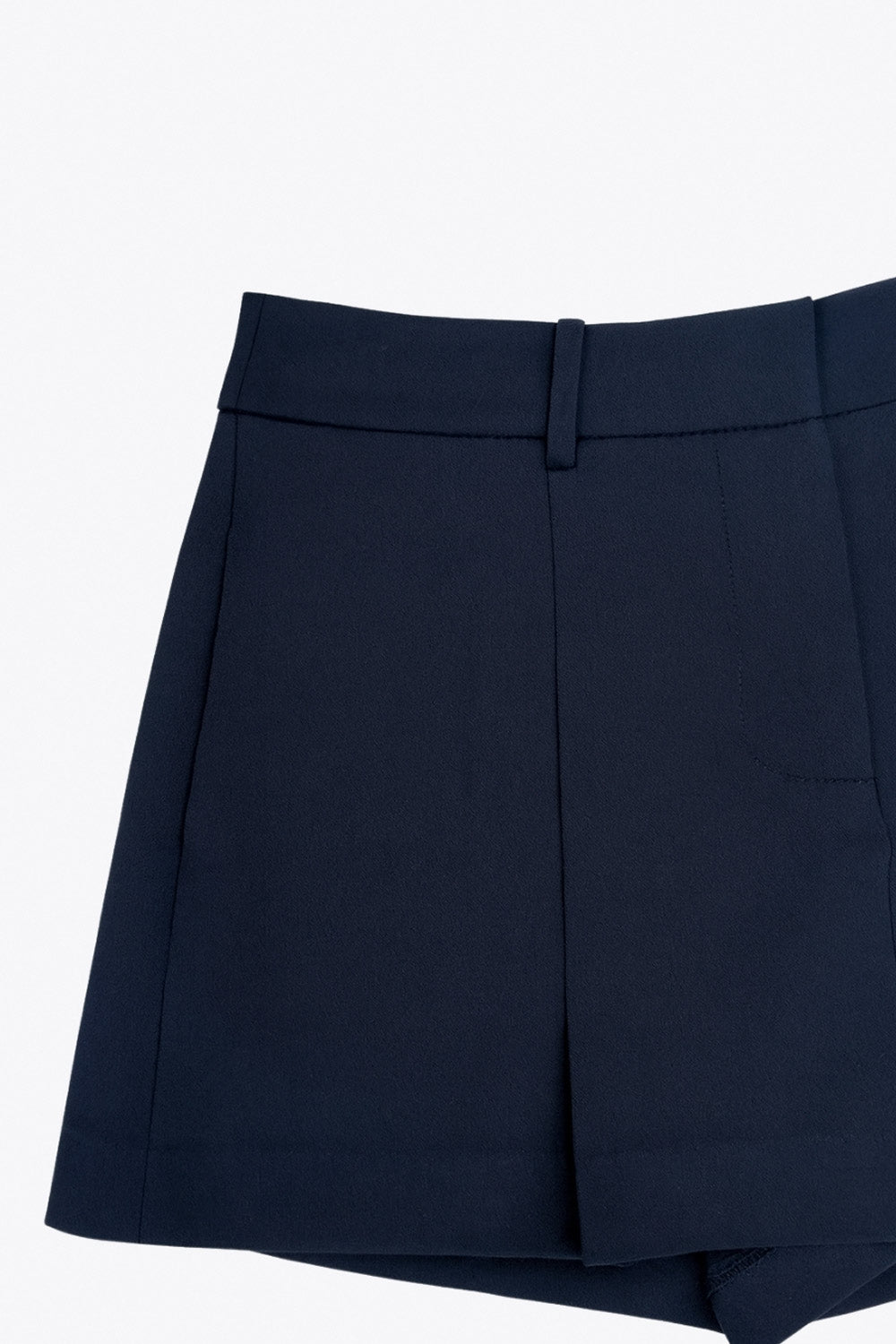 Falda short corto tableado de cintura alta con pretina y trabillas, corte en a, pinzas frontales y vivo decorativo posterior. Cierre frontal con broche y cremallera ocultos.