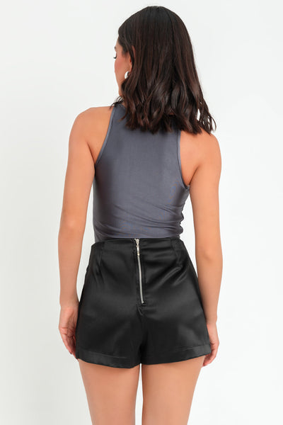 Falda short satinado de fit ajustado,cruce frontal con bajo curveado, cintura alta y cierre posterior con cremallera visible en contraste.
