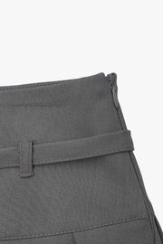 Falda short corto tableado, de corte en a, cintura alta con pretina, trabillas y lazo amarrable del tejido. Detalle de tableado en bajo y cierre lateral con cremallera oculta.
