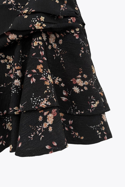 Falda short corto de estampado floral, cintura alta, corte en a, plisados en cadera, capas de olanes en bajo y cierre lateral con cremallera oculta.