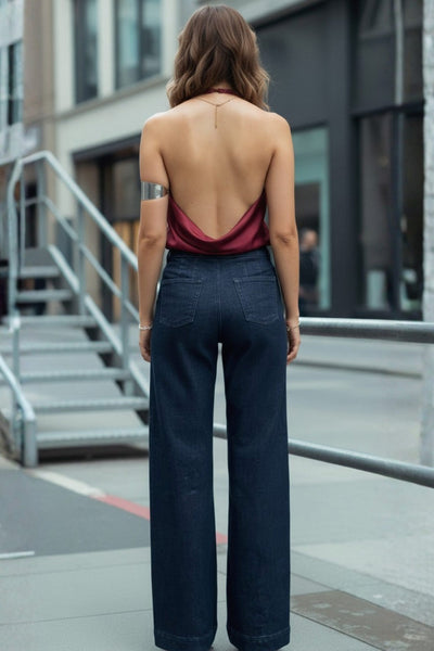 Pantalón de denim, fit wide leg, tiro alto, cintura alta con pretina y trabillas, bolsillos traseros de parche y cierre frontal con botones tipo marinero en contraste.