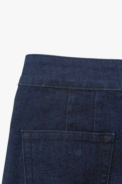 Pantalón de denim, fit wide leg, tiro alto, cintura alta con pretina y trabillas, bolsillos traseros de parche y cierre frontal con botones tipo marinero en contraste.