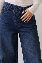 Pantalón de denim, fit wide leg, tiro alto, pretina criss cross con trabillas, bolsillos delanteros y traseros de parche. Cierre frontal con botón y cremallera oculta.