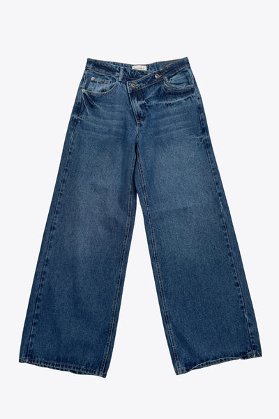 Pantalón de denim, fit wide leg, tiro alto, pretina criss cross con trabillas, bolsillos delanteros y traseros de parche. Cierre frontal con botón y cremallera oculta.