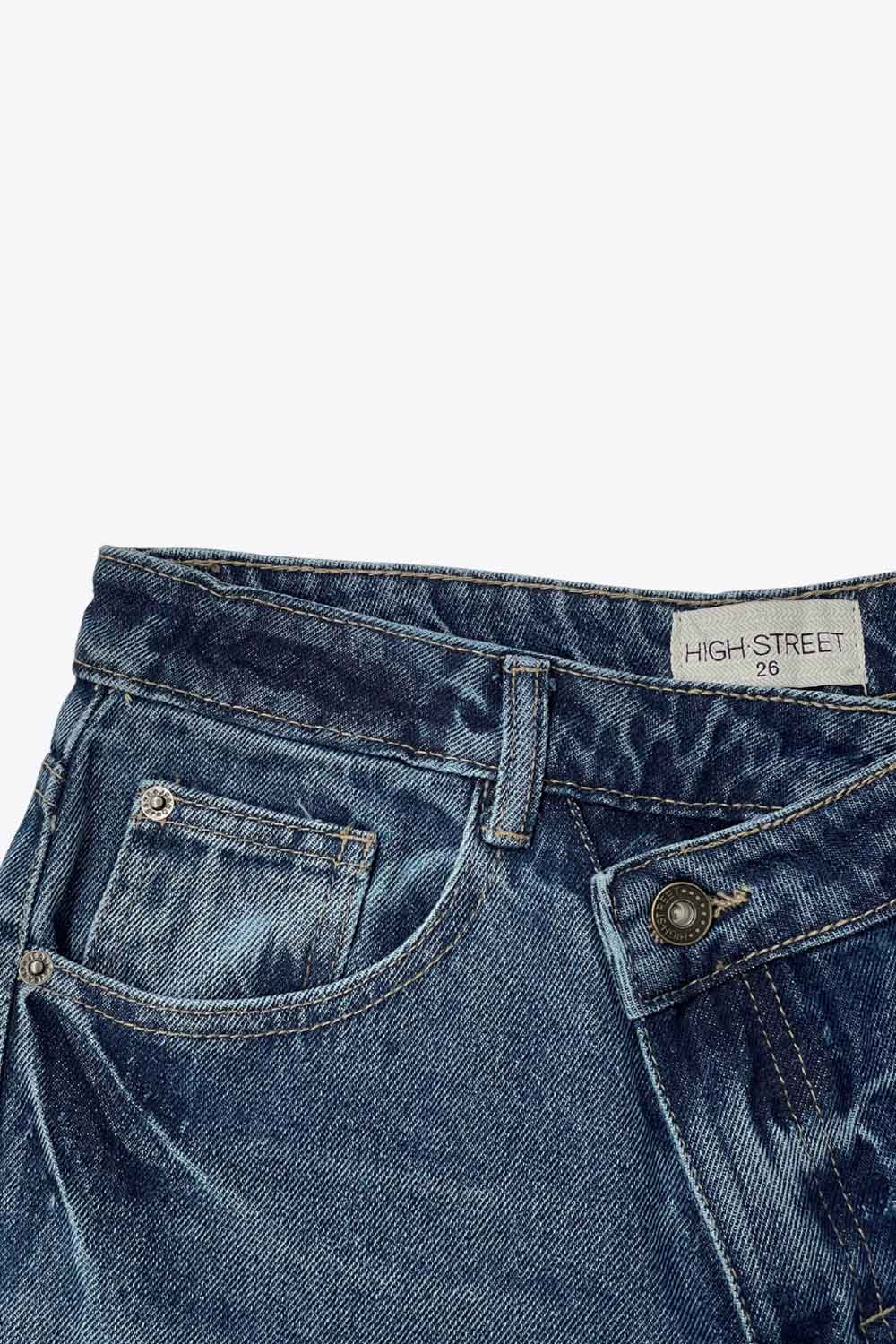 Pantalón de denim, fit wide leg, tiro alto, pretina criss cross con trabillas, bolsillos delanteros y traseros de parche. Cierre frontal con botón y cremallera oculta.