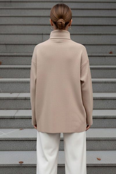 Jersey canalé de punto, fit oversized, cuello alto con doblez y manga larga.