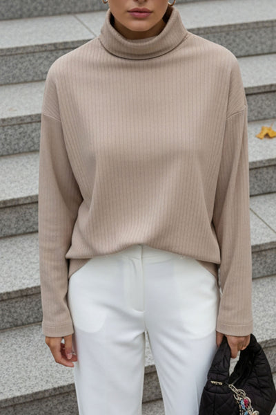 Jersey canalé de punto, fit oversized, cuello alto con doblez y manga larga.