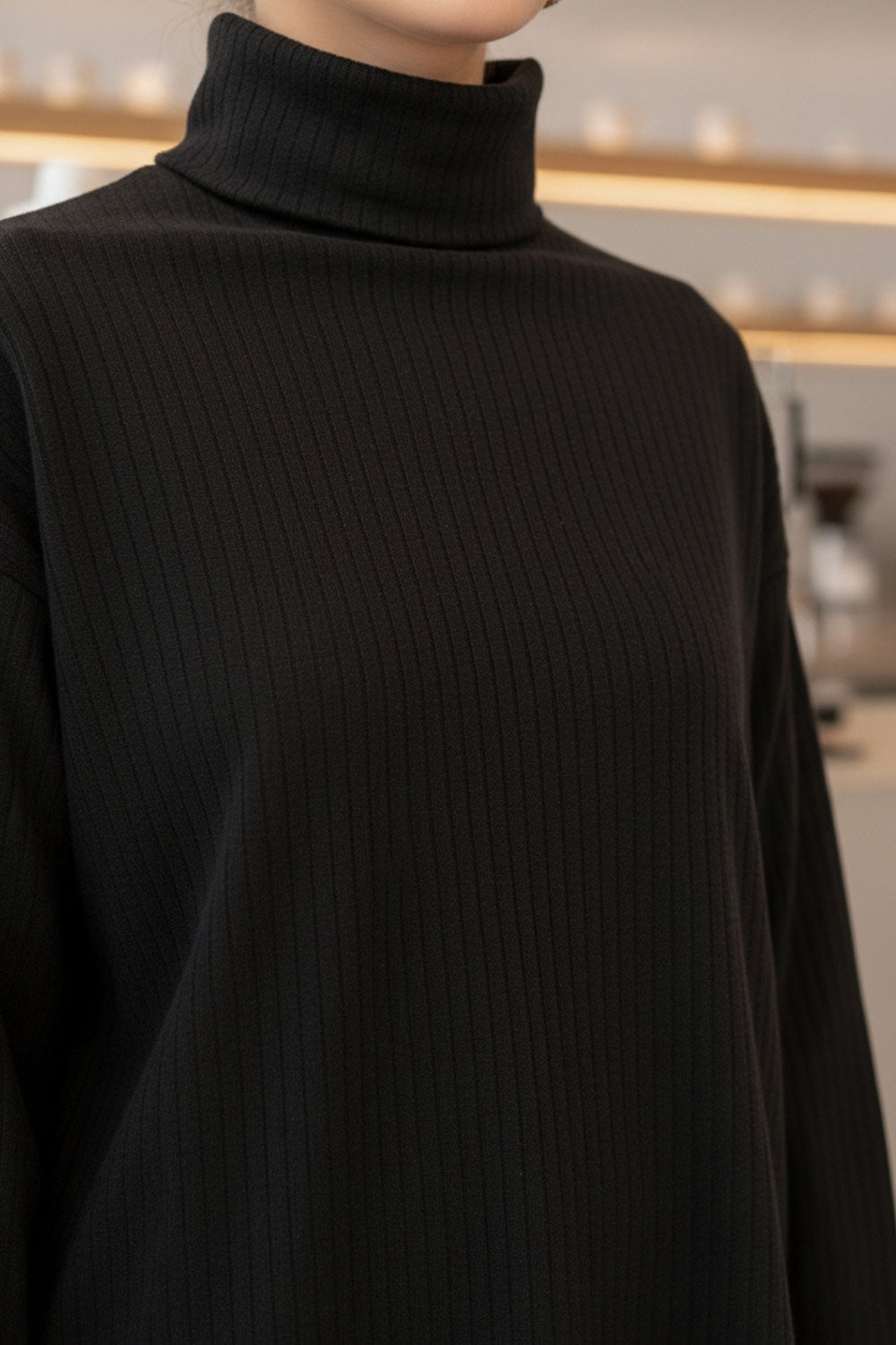 Jersey canalé de punto, fit oversized, cuello alto con doblez y manga larga.