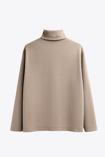 Jersey canalé de punto, fit oversized, cuello alto con doblez y manga larga.