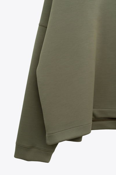 Jersey de fit fluido, cuello alto con doblez, manga larga con hombro caído y rib en puño.