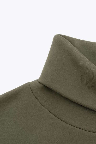 Jersey de fit fluido, cuello alto con doblez, manga larga con hombro caído y rib en puño.