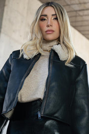 Jersey de punto, fit oversized, cuello alto y manga corta seguida.