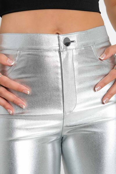Legging efecto piel metalizada de fit ajustado, cintura alta con pretina, bolsillos delanteros decorativos, cierre frontal con botón en contraste y cremallera oculta.