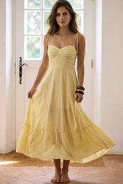 Maxi vestido de corte en a, tirantes delgados con nudo amarrable, escote corazón con cortes y detalles plisados. Cierre posterior con cremallera visible en contraste y olanes en borde de bajo.