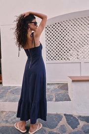 Maxi vestido de corte en a, tirantes delgados con nudo amarrable, escote corazón con cortes y detalles plisados. Cierre posterior con cremallera visible en contraste y olanes en borde de bajo.