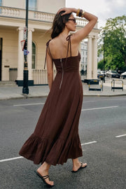 Maxi vestido de corte en a, tirantes delgados con nudo amarrable, escote corazón con cortes y detalles plisados. Cierre posterior con cremallera visible en contraste y olanes en borde de bajo.