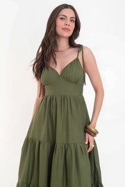 Maxi vestido de escote v con cortes y plisados decorativos, tirantes delgados con nudo amarrable, corte en a, bajo con capas de olanes y cierre posterior con cremallera visible en contraste.
