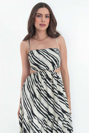 Maxi vestido estampado de corte en a, tirantes delgados ajustables, bajo con capas de olanes, cut out en costados y espalda. Detalle de rib elástico en cintura y cierre lateral con cremallera oculta.