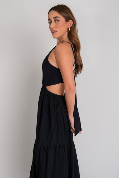 Maxi vestido de cuello halter con tirantes delgados ajustables, corte en a, bajo con capas de olanes, cut out en costados y espalda. Detalle de rib elástico en cintura y cierre posterior con lazo amarrable.