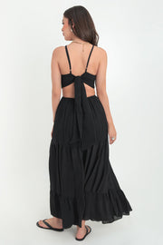 Maxi vestido de cuello halter con tirantes delgados ajustables, corte en a, bajo con capas de olanes, cut out en costados y espalda. Detalle de rib elástico en cintura y cierre posterior con lazo amarrable.