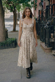 Maxi vestido estampado, de corte en a, tirantes con nudo amarrable, escote corazón con cortes y detalles plisados. Cierre posterior con cremallera oculta.
