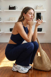 Palazzo ajustado de fit wide leg, cuello halter con lazo amarrable posterior, cut out en costados y espalda. Detalle de fruncido en espalda.