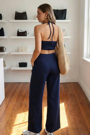 Palazzo ajustado de fit wide leg, cuello halter con lazo amarrable posterior, cut out en costados y espalda. Detalle de fruncido en espalda.