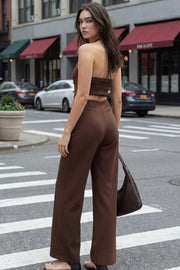 Palazzo ajustado de fit wide leg, cuello halter con lazo amarrable posterior, cut out en costados y espalda. Detalle de fruncido en espalda.