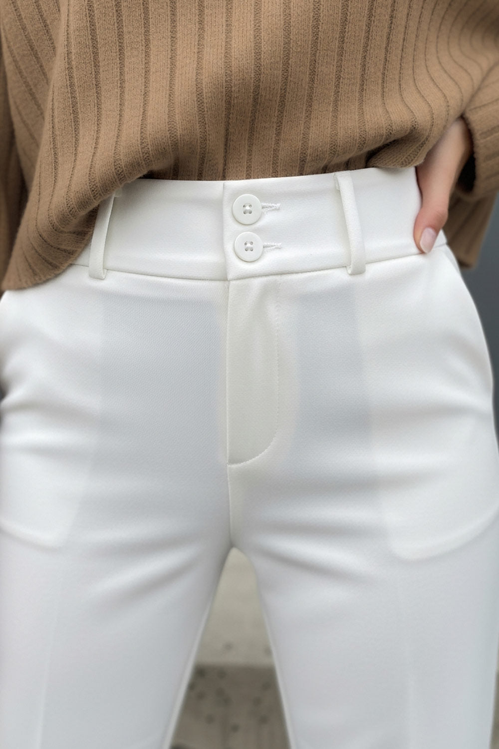 Pantalón ajustado de fit flare, cintura alta con pretina y trabillas, raya frontal y posterior, cierre con cremallera oculta y botones.