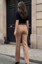 Pantalón ajustado de fit flare, cintura alta con pretina y trabillas, raya frontal y posterior, cierre con cremallera oculta y botones.