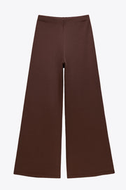 Pantalón fluido de fit wide leg y cintura alta con pretina elástica. Detalle de textura en tejido.
