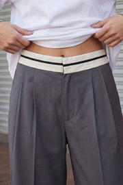 Pantalón de fit wide leg, pinzas frontales, cintura media con detalle de pretina en contraste, bolsillos delanteros y vivos decorativos posteriores. Detalle de raya frontal y posterior. Cierre frontal con broche y cremallera ocultos.