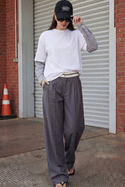 Pantalón de fit wide leg, pinzas frontales, cintura media con detalle de pretina en contraste, bolsillos delanteros y vivos decorativos posteriores. Detalle de raya frontal y posterior. Cierre frontal con broche y cremallera ocultos.