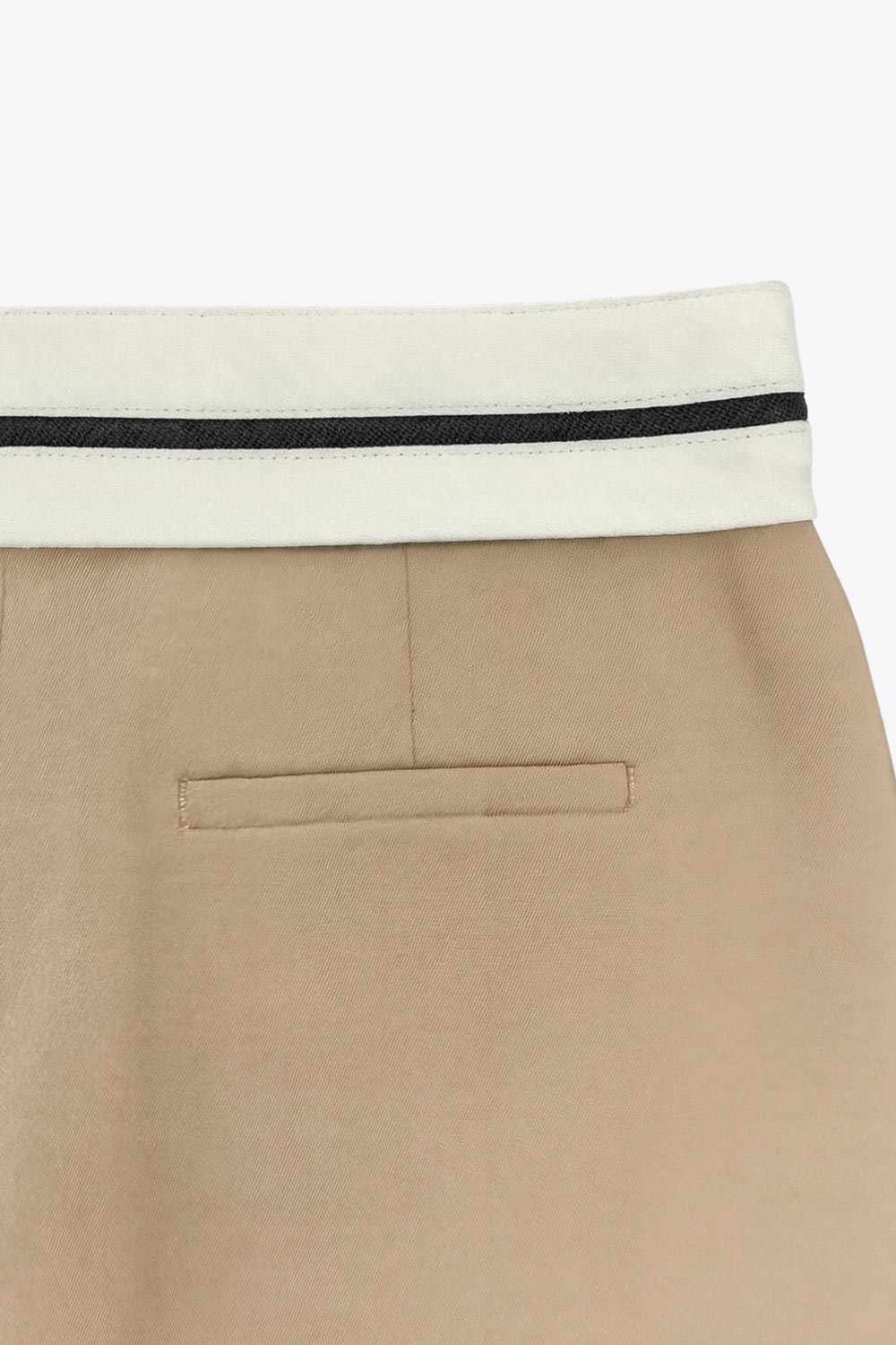 Pantalón de fit wide leg, pinzas frontales, cintura media con detalle de pretina en contraste, bolsillos delanteros y vivos decorativos posteriores. Detalle de raya frontal y posterior. Cierre frontal con broche y cremallera ocultos.