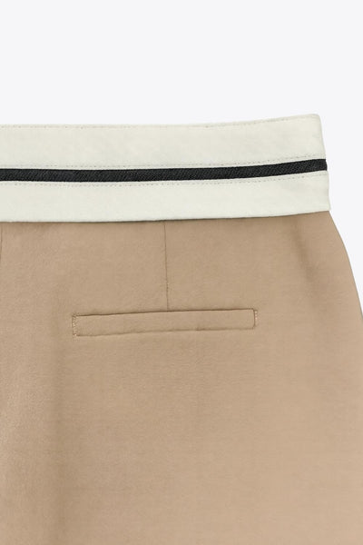 Pantalón de fit wide leg, pinzas frontales, cintura media con detalle de pretina en contraste, bolsillos delanteros y vivos decorativos posteriores. Detalle de raya frontal y posterior. Cierre frontal con broche y cremallera ocultos.