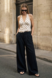 Pantalón de fit palazzo, cintura alta con trabillas, pinzas frontales, bolsillos delanteros y vivos decorativos posteriores, raya frontal y posterior. Cierre frontal con broche y cremallera ocultos.