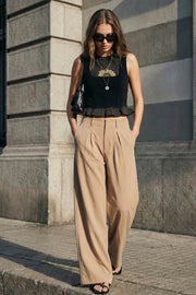 Pantalón de fit palazzo, cintura alta con trabillas, pinzas frontales, bolsillos delanteros y vivos decorativos posteriores, raya frontal y posterior. Cierre frontal con broche y cremallera ocultos.