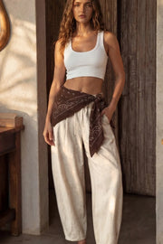 Pantalón de lino, fit balloon, pinzas con cortes frontales, cintura alta con pretina elástica y jareta frontal ajustable, bolsillos delanteros y pinzas en bajo.