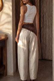 Pantalón de lino, fit balloon, pinzas con cortes frontales, cintura alta con pretina elástica y jareta frontal ajustable, bolsillos delanteros y pinzas en bajo.