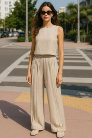 Pantalón de fit palazzo, cintura alta con pretina elástica, bolsillos delanteros y pinzas frontales.