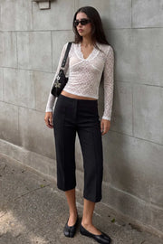 Pantalón capri de fit ajustado, cintura media, vivos decorativos frontales, detalle de raya y abertura lateral en bajo. Cierre frontal con broche y cremallera ocultos.