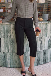 Pantalón capri de fit ajustado, cintura media, vivos decorativos frontales, detalle de raya y abertura lateral en bajo. Cierre frontal con broche y cremallera ocultos.